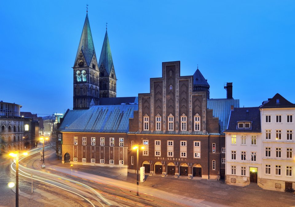 Ein rotes Backsteinhaus mit dem Dom im Hintergrund